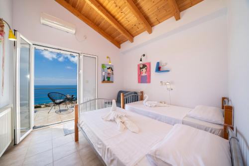 2 letti in una camera con vista sull'oceano di Κefalonia Golden View Villa a Cefalonia