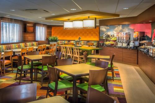 a restaurant with tables and chairs and a bar at Fairfield Inn & Suites Dulles Airport in Sterling
