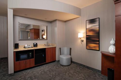 a hotel room with a sink and a mirror at Courtyard Atlanta McDonough in McDonough