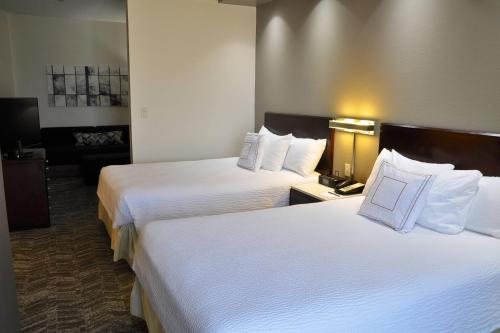 a hotel room with two beds with white sheets at SpringHill Suites Houston Katy Mills in Katy