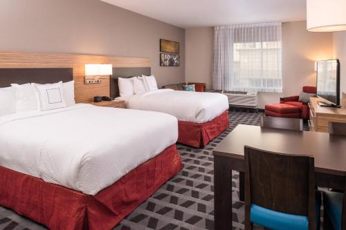 a hotel room with two beds and a desk at TownePlace Suites by Marriott Merced in Merced