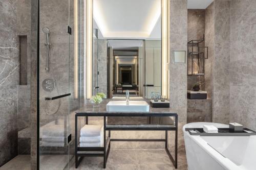 uma casa de banho com um lavatório, uma banheira e um chuveiro em Xiamen Marriott Hotel Haicang em Xiamen