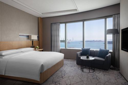 a hotel room with a bed and a large window at Xiamen Marriott Hotel Haicang in Xiamen