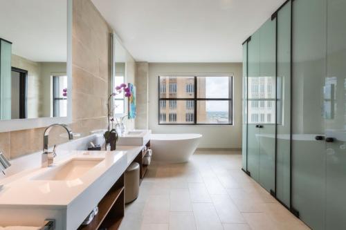 a bathroom with two sinks and a tub and a shower at JW Marriott Houston Downtown in Houston
