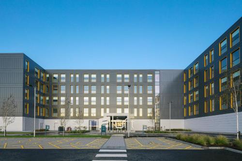 um grande edifício com um parque de estacionamento em frente em Aloft Aberdeen TECA em Aberdeen