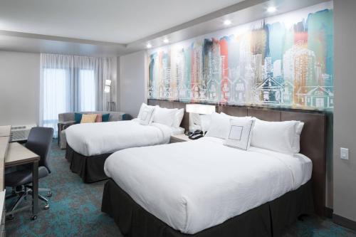 ヒューストンにあるCourtyard by Marriott Houston Heights/I-10のベッド2台とデスクが備わるホテルルームです。