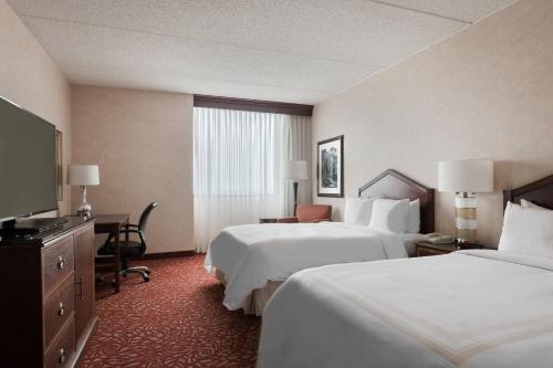 ein Hotelzimmer mit 2 Betten und einem Flachbild-TV in der Unterkunft Chicago Marriott Northwest in Hoffman Estates