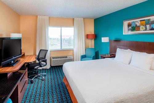 Habitación de hotel con cama, escritorio y TV. en Fairfield Inn & Suites Cheyenne, en Cheyenne