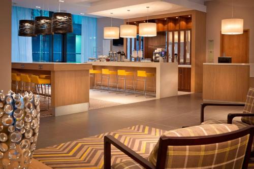 um restaurante com um bar com cadeiras e mesas amarelas em Residence Inn by Marriott Edinburgh em Edimburgo