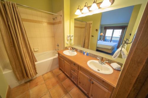 a bathroom with two sinks and a large mirror at Springs 8910 in Keystone