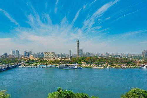 uma vista para um rio com barcos numa cidade em The Nile Ritz-Carlton, Cairo em Cairo