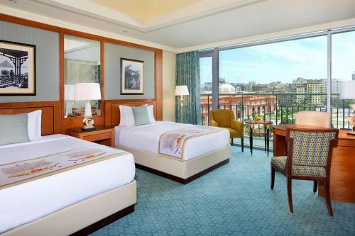 a hotel room with two beds and a desk and a window at The Nile Ritz-Carlton, Cairo in Cairo