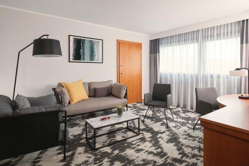 a living room with a couch and a table at Sheraton Frankfurt Airport Hotel & Conference Center in Frankfurt/Main