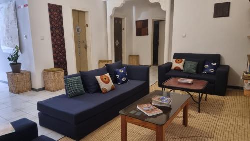 a living room with blue couches and a table at Le k in Nouakchott