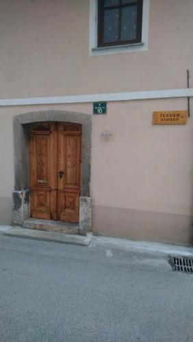 eine Holztür an der Seite eines Gebäudes in der Unterkunft Apartment Room Old City - Apartment Slavija in Škofja Loka
