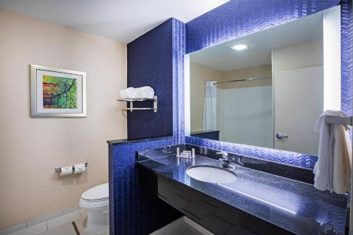 Baño azul con lavabo y aseo en Fairfield Inn & Suites Tulsa Downtown Arts District en Tulsa