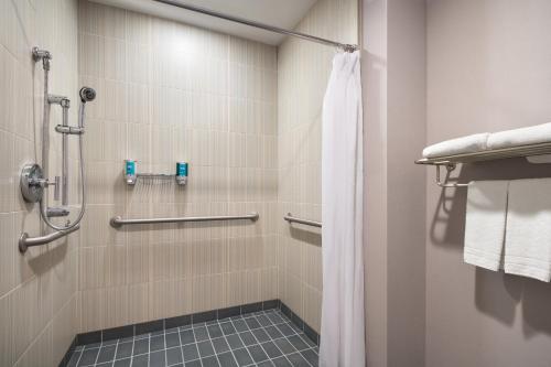 La salle de bains est pourvue d'une douche avec rideau de douche. dans l'établissement Aloft Tempe, à Tempe