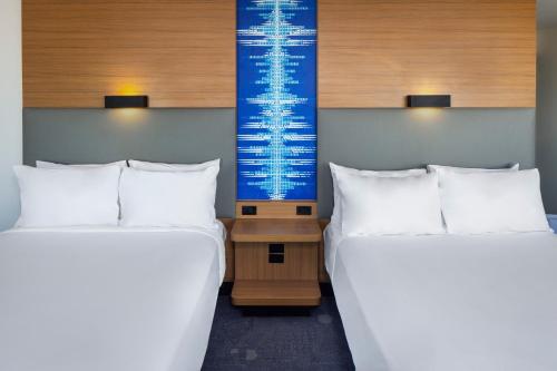 two beds sitting next to each other in a room at Aloft Tempe in Tempe