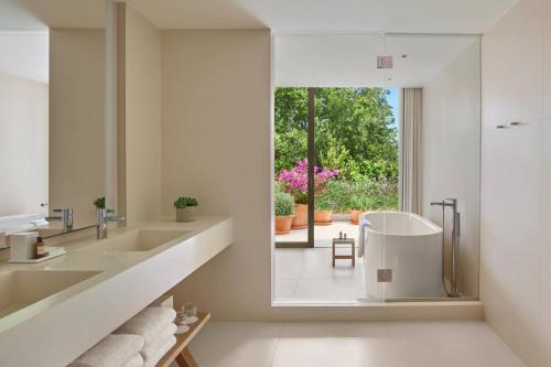 a bathroom with a tub and a sink and a window at The West Hollywood EDITION in Los Angeles