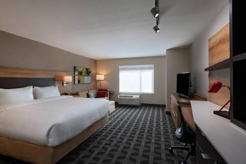 a hotel room with a bed and a flat screen tv at TownePlace Suites San Antonio Northwest at The RIM in San Antonio