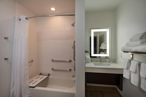 y baño con bañera, lavamanos y ducha. en TownePlace Suites San Antonio Northwest at The RIM en San Antonio