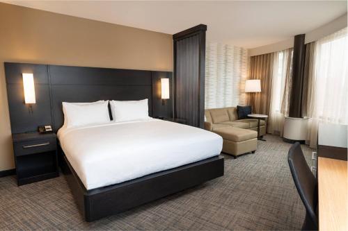 a hotel room with a large bed and a chair at Residence Inn by Marriott Grand Rapids Downtown in Grand Rapids