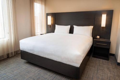a bedroom with a large bed with white sheets and pillows at Residence Inn by Marriott Grand Rapids Downtown in Grand Rapids