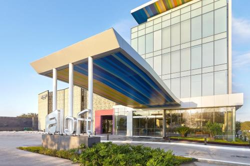 a large building with a blue and white facade at Aloft Queretaro in Querétaro