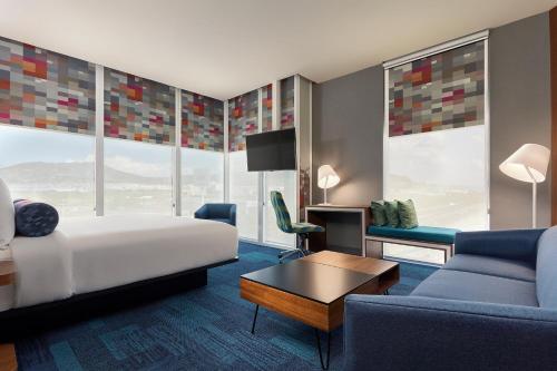a hotel room with a bed and a couch at Aloft Queretaro in Querétaro