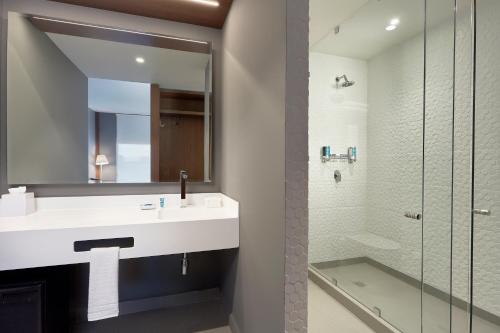 y baño con lavabo y ducha. en Aloft Queretaro en Querétaro