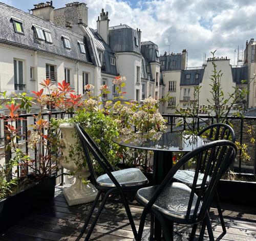 d'une table et de chaises sur un balcon fleuri dans l'établissement Beausejour Ranelagh, à Paris