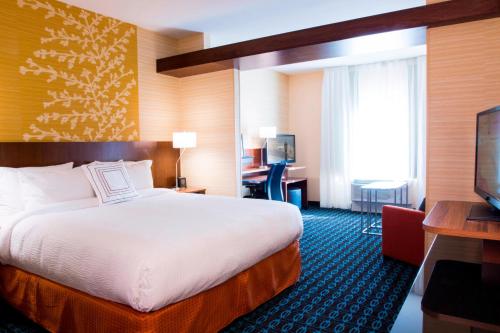 a hotel room with a large bed and a desk at Fairfield by Marriott The Dalles in The Dalles