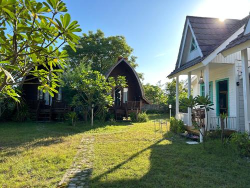 a house with a grass yard in front of it at Balakosa Gili Meno Bungalow in Gili Meno
