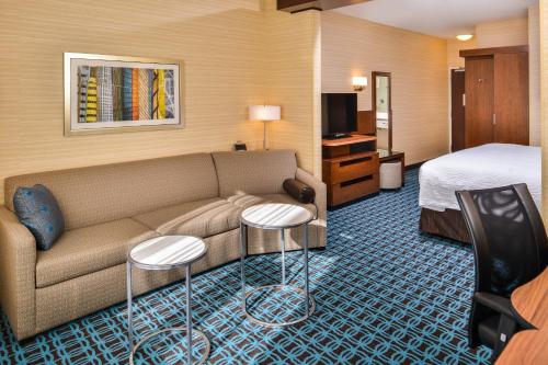 Fairfield Inn & Suites by Marriott Eugene East/Springfield في يوجين: غرفة في الفندق مع أريكة وسرير