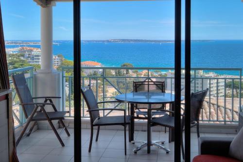 un balcon avec une table et des chaises et l'océan dans l'établissement IMMOGROOM - 2 Rooms sea view - Swimming pool - Terrace - Parking - AC, à Cannes