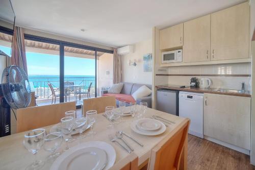 une cuisine avec une table avec des verres à vin dessus dans l'établissement IMMOGROOM - 2 Rooms sea view - Swimming pool - Terrace - Parking - AC, à Cannes
