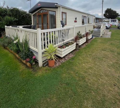 a house with a white fence and some plants at The Helmsley lodge lido beach Prestatyn northwales in Prestatyn