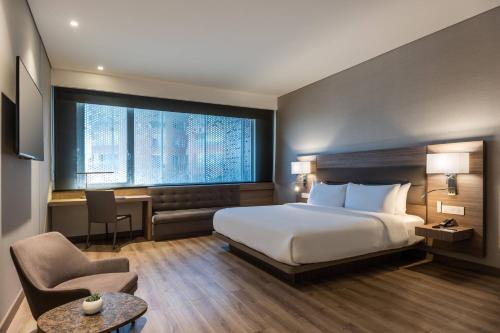 a hotel room with a bed and a chair at AC Hotel by Marriott Bogota Zona T in Bogotá