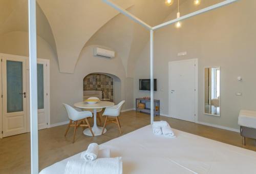 un soggiorno con tavolo e sedie di Palazzo Junno Dimora D'Epoca a Mattinata