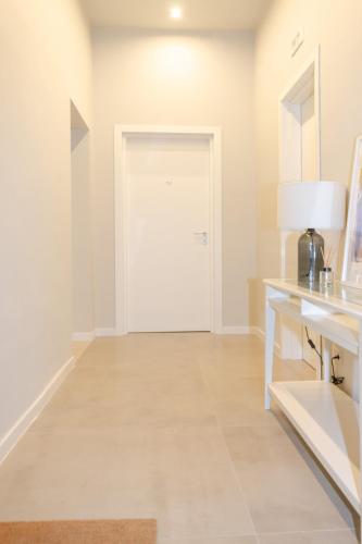 a hallway with a white door and a table with a lamp at Palazzo Junno Dimora D'Epoca in Mattinata