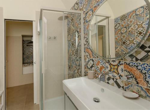 a bathroom with a sink and a mirror at Palazzo Junno Dimora D'Epoca in Mattinata