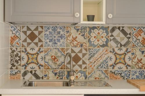 a kitchen with a sink and tiles on the wall at Palazzo Junno Dimora D'Epoca in Mattinata