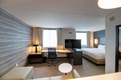 a hotel room with a bed and a desk with a computer at Residence Inn by Marriott Fort Worth Southwest in Fort Worth