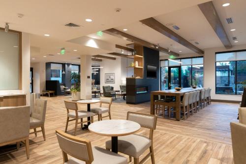 a waiting room with tables and chairs and windows at Residence Inn by Marriott Fort Worth Southwest in Fort Worth