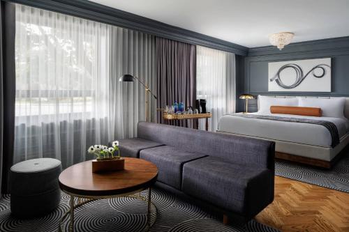 ein Hotelzimmer mit einem Bett, einem Sofa und einem Bett in der Unterkunft The Drake Oak Brook, Autograph Collection in Oak Brook