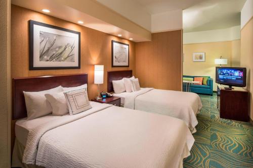 a hotel room with two beds and a flat screen tv at SpringHill Suites Laredo in Laredo