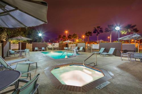 a swimming pool at night with chairs and an umbrella at SpringHill Suites Laredo in Laredo