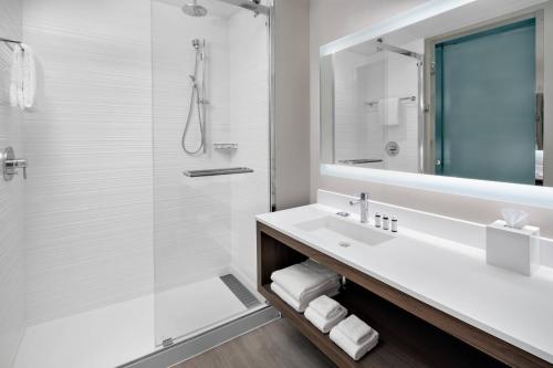 uma casa de banho com um lavatório e um chuveiro em AC Hotel by Marriott Kingston, Jamaica em Kingston