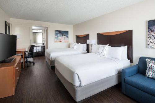 a hotel room with two beds and a tv at Fairfield by Marriott Anaheim Resort in Anaheim