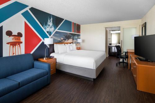 a hotel room with a bed and a couch and a tv at Fairfield by Marriott Anaheim Resort in Anaheim